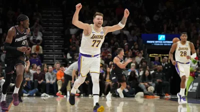 Los Angeles Lakers guard Luka Doncic (77) reacts after scoring against the Phoenix Suns during the second half of an NBA basketball game, Sunday, Dec. 14, 2025, in Phoenix. (AP Photo/Rick Scuteri)
