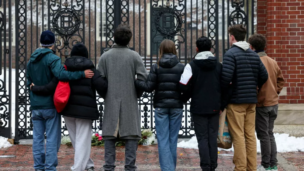 Students stand in front of the Van Wickle Gates after placing flowers, following a shooting at Brown University, in Providence, Rhode Island, U.S. December 14, 2025. REUTERS/Kylie Cooper   TPX IMAGES OF THE DAY