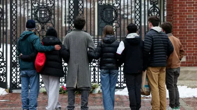 Students stand in front of the Van Wickle Gates after placing flowers, following a shooting at Brown University, in Providence, Rhode Island, U.S. December 14, 2025. REUTERS/Kylie Cooper   TPX IMAGES OF THE DAY