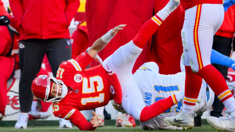 Kansas City Chiefs quarterback Patrick Mahomes (15) is injured after being tackled by Los Angeles Chargers defensive tackle Da'Shawn Hand (91) during the second half of an NFL football game, Sunday, Dec. 14, 2025 in Kansas City, Mo. (AP Photo/Reed Hoffmann)