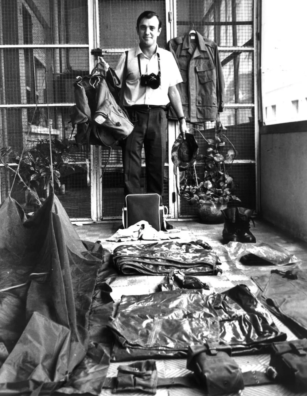 FILE - Associated Press correspondent Peter Arnett stands with gear that he carries out in field while covering the Vietnamese army 1963, in Saigon, Vietnam. (AP Photo, File)