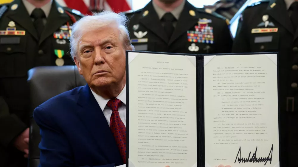U.S. President Donald Trump shows a signed executive order classifying fentanyl as 'weapon of mass destruction' during a Mexican Border Defense Medal presentation in the Oval Office at the White House in Washington, D.C., U.S., December 15, 2025. REUTERS/Evelyn Hockstein