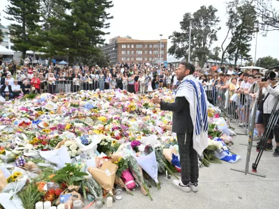 16 December 2025, Australia, Sydney: A rabbi address mourners at a memorial at Bondi Beach after gunmen opened fire, killing 15 people in an attack designed to target the Jewish community. Photo: Mick Tsikas/AAP/dpa