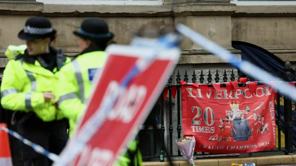 FILE PHOTO: Police officers operate as a Liverpool FC flag is seen in the background at the site of an incident where a car ploughed into a crowd of Liverpool fans during a parade celebrating their side's Premier League soccer title, in central Liverpool, Britain, May 27, 2025. REUTERS/Isabel Infantes/File Photo