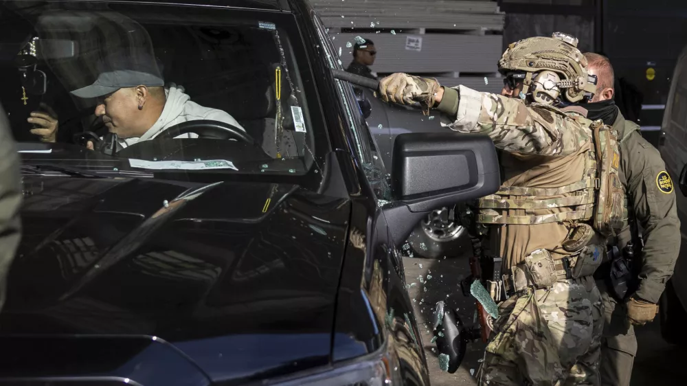 Federal immigration enforcement agents shatter a truck window and detain two men outside a Home Depot in Evanston, Ill., Wednesday, Dec. 17, 2025. (Ashlee Rezin/Chicago Sun-Times via AP) / Foto: Ashlee Rezin