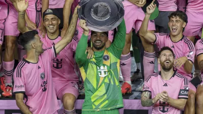 Inter Miami forward Lionel Messi, front right, celebrates with his teammates Sergio Busquets, front left, Luis Su&aacute;rez, second row, left, and Drake Callender, center in green, after winning the Supporters' Shield defeating the New England Revolution at Chase Stadium in Fort Lauderdale, Fla., Saturday, Oct. 19, 2024. (David Santiago/Miami Herald via AP)