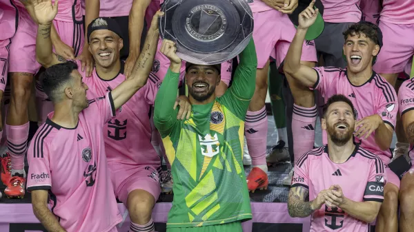 Inter Miami forward Lionel Messi, front right, celebrates with his teammates Sergio Busquets, front left, Luis Su&aacute;rez, second row, left, and Drake Callender, center in green, after winning the Supporters' Shield defeating the New England Revolution at Chase Stadium in Fort Lauderdale, Fla., Saturday, Oct. 19, 2024. (David Santiago/Miami Herald via AP)