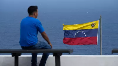 A man looks out at the sea in the city of La Guaira, Venezuela, where the nation's flag flies, Wednesday, Dec. 17, 2025. (AP Photo/Ariana Cubillos)