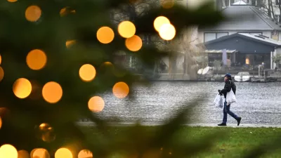 PRODUCTION - 22 December 2025, Berlin: A young man carrying shopping bags walks along the banks of the Mueggelspree in the old town of Koepenick. Photo: Britta Pedersen/dpa / Foto: Britta Pedersen