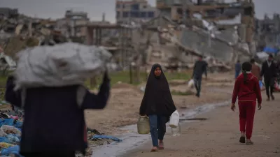 A Palestinian woman carries a container of water in Nuseirat, central Gaza Strip, Friday, Jan. 2, 2026. (AP Photo/Abdel Kareem Hana) / Foto: Abdel Kareem Hana