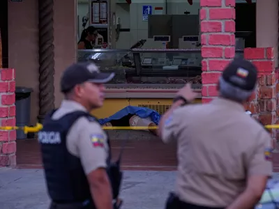 The body of slain soccer player Mario Pineida lies on the floor at a butcher shop in Guayaquil, Ecuador, Wednesday, Dec. 17, 2025. (AP Photo/Cesar Munoz)