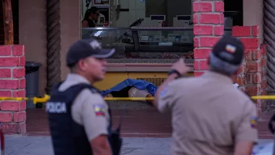 The body of slain soccer player Mario Pineida lies on the floor at a butcher shop in Guayaquil, Ecuador, Wednesday, Dec. 17, 2025. (AP Photo/Cesar Munoz)