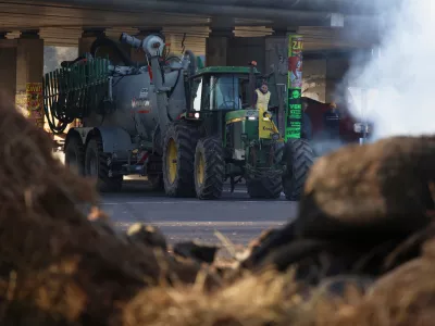 French farmers unload manure as they protest against the Mercosur trade deal with South American nations, Thursday, Dec. 18, 2025 in Portet-sur-Garonne, southwestern France. (AP Photo/Fred Scheiber)