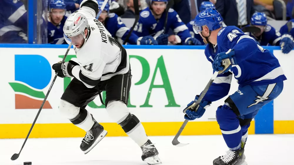 Los Angeles Kings center Anze Kopitar (11) beats Tampa Bay Lightning defenseman Darren Raddysh (43) up the ice during the third period of an NHL hockey game Thursday, Dec. 18, 2025, in Tampa, Fla. (AP Photo/Chris O'Meara)