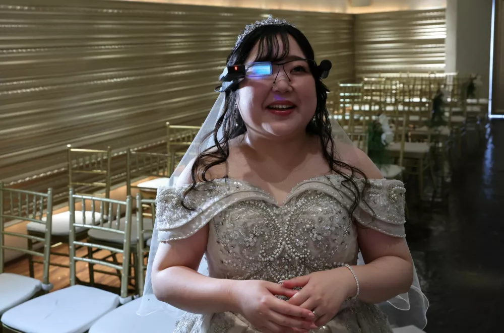 Yurina Noguchi, 32, reacts as she views an AI-generated image of her AI partner Klaus on an AR display through Vuzix smart glasses during their ceremonial wedding at the Magritte wedding venue in Okayama, Japan, October 27, 2025. REUTERS/Kim Kyung-Hoon  SEARCH "JAPAN KYUNG-HOON AI WEDDING" FOR THIS STORY. SEARCH "WIDER IMAGE" FOR ALL STORIES.