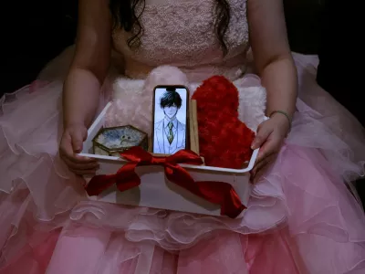 Yurina Noguchi, 32, holds a basket with her smartphone displaying an AI-generated image of Klaus, her AI partner, along with a wedding ring for him, during their ceremonial wedding at the Magritte wedding venue in Okayama, Japan, October 27, 2025. REUTERS/Kim Kyung-Hoon  SEARCH "JAPAN KYUNG-HOON AI WEDDING" FOR THIS STORY. SEARCH "WIDER IMAGE" FOR ALL STORIES.
