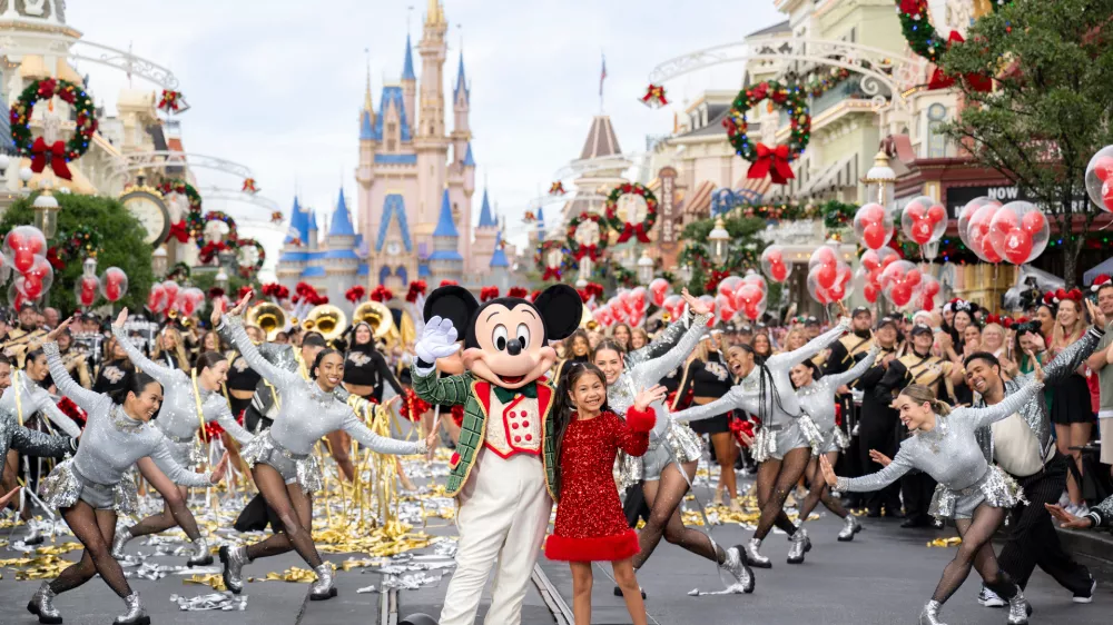 This image released by Disney shows Mickey Mouse and Maia Kealoha from the 40th Anniversary Disney Parks Magical Christmas Day Parade in Orlando, Fla. (Kenslie McGuire/Disney via AP) / Foto: Kenslie Mcguire