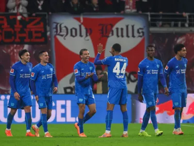 Montrell Culbreath of Bayer Leverkusen, third from left, celebrates with teammates after scoring to make it 1:3 during the Bundesliga soccer match between RB Leipzig and Bayer Leverkusen, in Leipzig, Germany, Saturday Dec. 20, 2025. (Jan Woitas/dpa via AP)