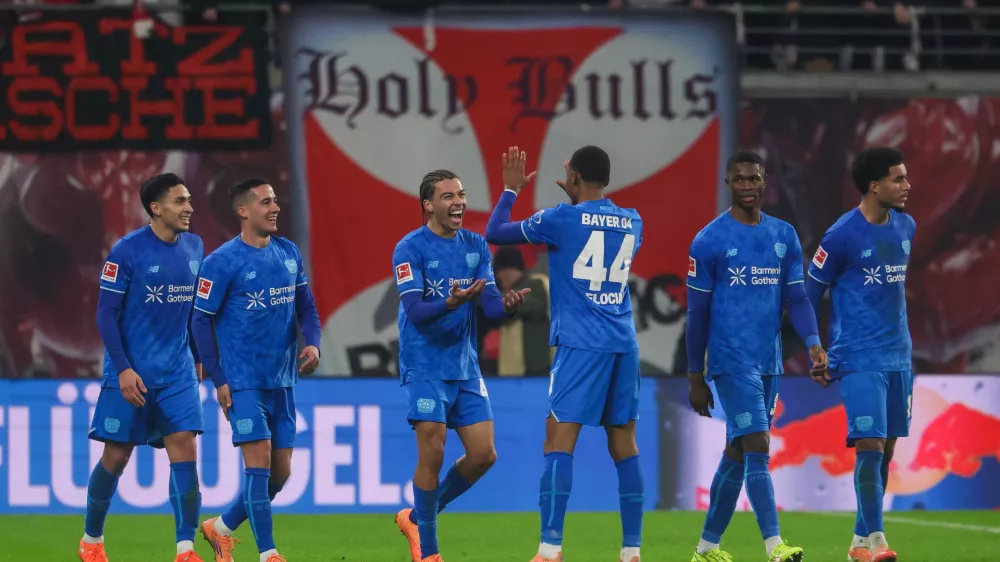 Montrell Culbreath of Bayer Leverkusen, third from left, celebrates with teammates after scoring to make it 1:3 during the Bundesliga soccer match between RB Leipzig and Bayer Leverkusen, in Leipzig, Germany, Saturday Dec. 20, 2025. (Jan Woitas/dpa via AP)