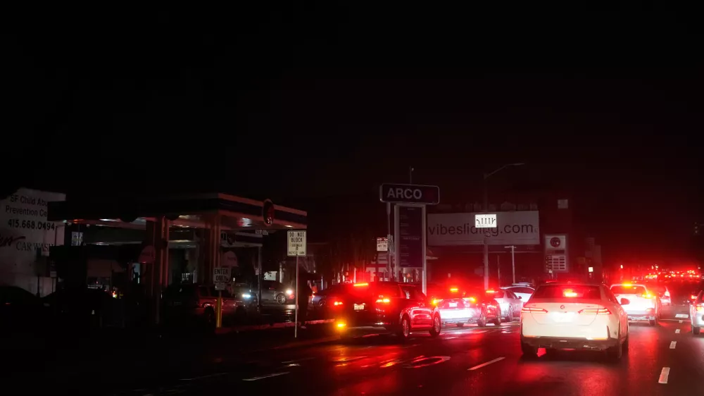 Cars wait at an intersection with no working traffic lights from power outages, in San Francisco, Saturday, Dec. 20, 2025. (AP Photo/Jeff Chiu)