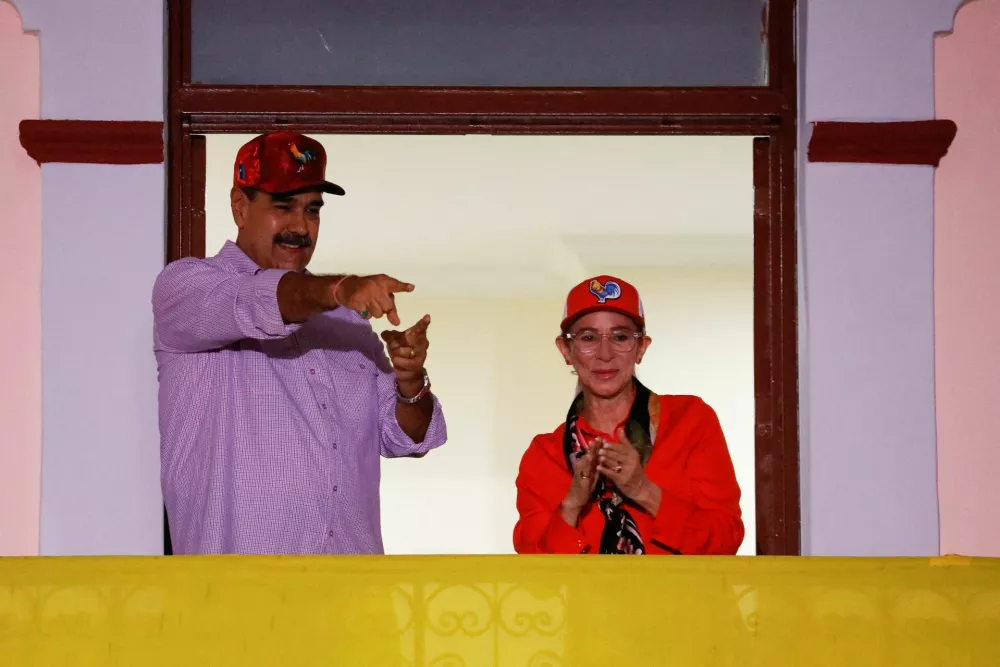 FILE PHOTO: Venezuelan President Nicolas Maduro and his wife Cilia Flores greet supporters during a march, marking the first anniversary of his victory in the disputed July 28 presidential election, in Caracas, Venezuela July 28, 2025. REUTERS/Leonardo Fernandez Viloria/File Photo