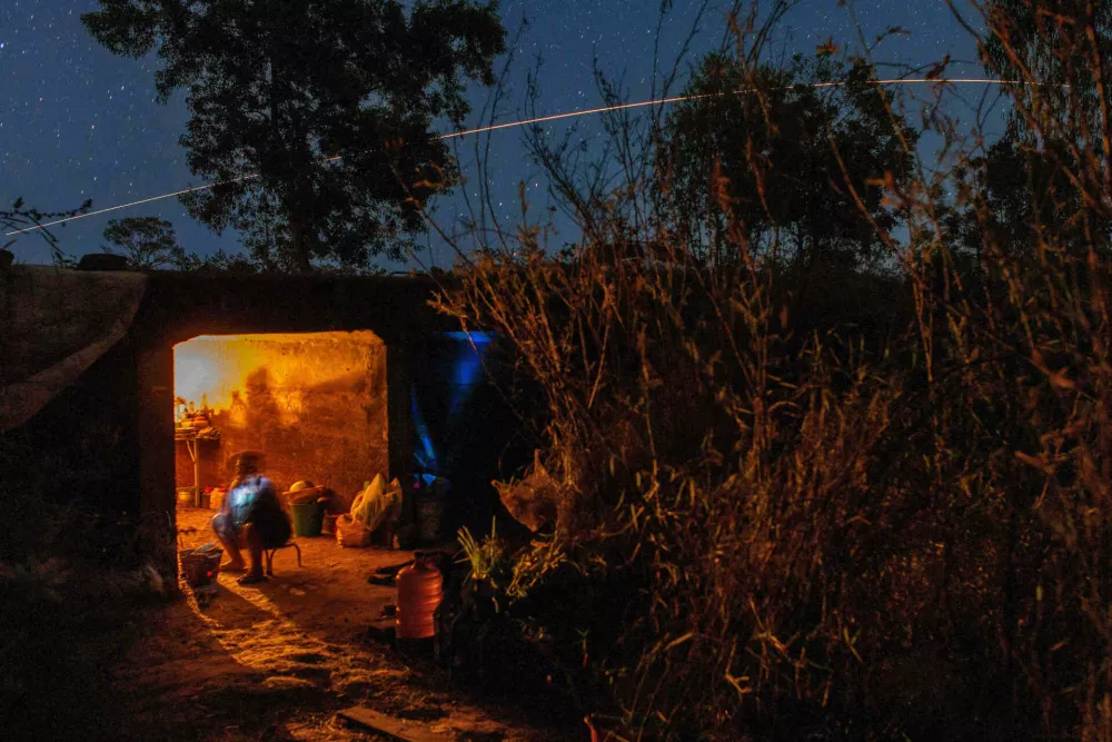 Thai resident cooks in a shelter while Thai military fires artillery towards Cambodia, Saturday, Dec. 20, 2025, in Surin province, Thailand. (AP Photo/Wason Wanichakorn)