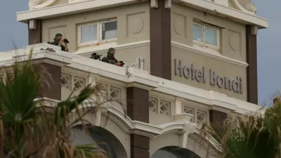 Security watch over from the roof of Hotel Bondi the 'Light Over Darkness' vigil commemorating victims and survivors of a deadly mass shooting during a Jewish Hanukkah celebration at Bondi Beach on December 14, in Sydney, Australia, December 21, 2025. REUTERS/Hollie Adams   TPX IMAGES OF THE DAY