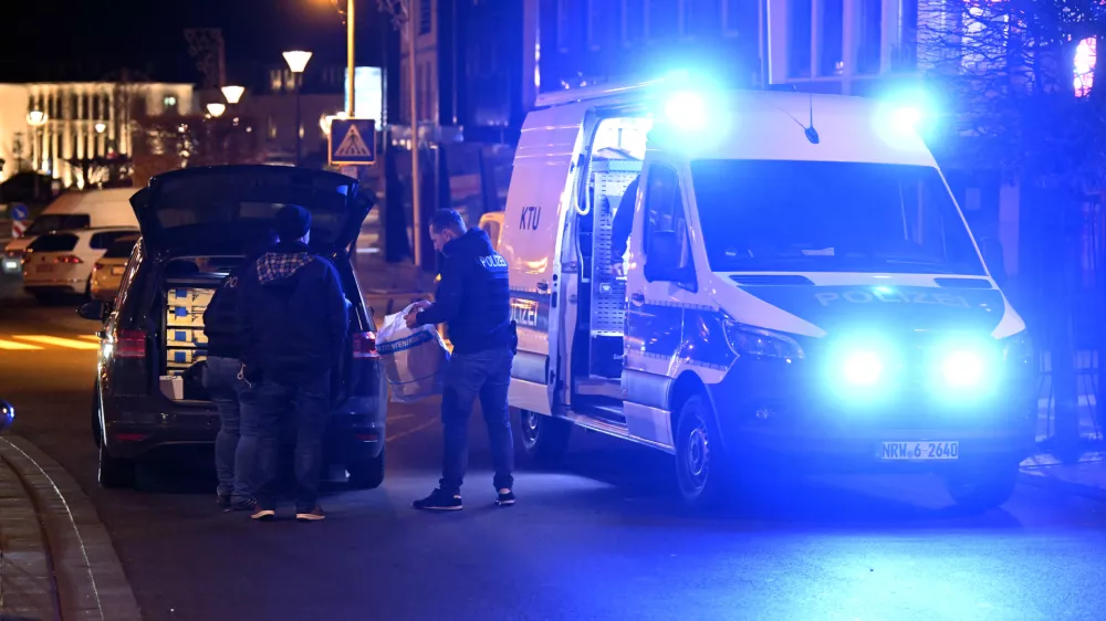 21 December 2025, North Rhine-Westphalia, Geilenkirchen: Police officers stand at the scene in the city center of Geilenkirchen, where shots were fired. A man was shot and injured. Photo: Roberto Pfeil/dpa