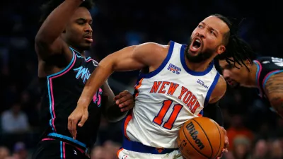 Miami Heat guard Davion Mitchell, left, defends against New York Knicks guard Jalen Brunson (11) during the first half of an NBA basketball game Sunday, Dec. 21, 2025, in New York. (AP Photo/John Munson)