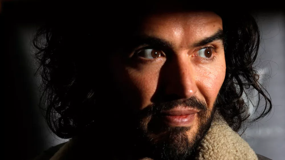 FILE PHOTO: Comedian Russell Brand poses for photographers before signing copies of his new book entitled "Revolution" in central London, December 5, 2014. REUTERS/Suzanne Plunkett/File Photo