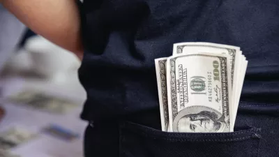 Hand holding loan money dollar bank note give financial payment. Man hands showing spread 100 dollar exchange cash payout. Saving Businessman counting money banknote bribe corruption concept. / Foto: Howtogoto, Getty Images