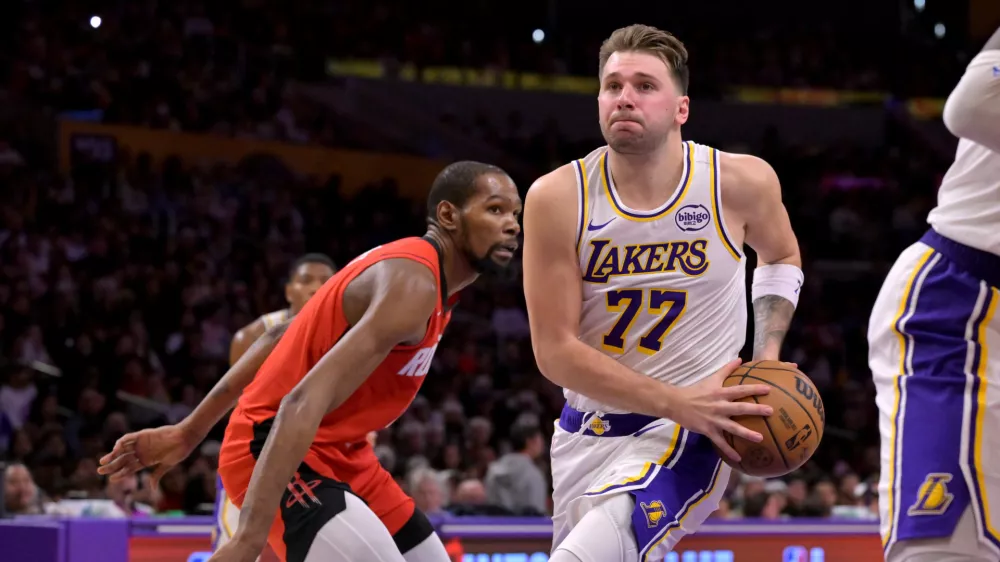 Los Angeles Lakers guard Luka Doncic (77) drives to the basket past Houston Rockets forward Kevin Durant during the second half of an NBA basketball game, Thursday, Dec. 25, 2025, in Los Angeles. (AP Photo/Jayne Kamin-Oncea)