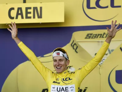 Cycling - Tour de France - Stage 5 - Caen to Caen - Caen, France - July 9, 2025 UAE Team Emirates XRG's Tadej Pogacar celebrates on the podium wearing the yellow jersey after stage 5 REUTERS/Benoit Tessier