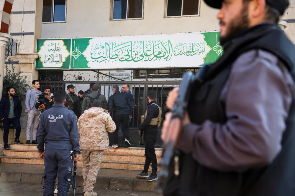 Syrian security forces gather outside the Imam Ali bin Abi Talib Mosque after an explosion inside the mosque in the predominantly Alawite Wadi al-Dhahab neighborhood of Homs, Syria, Friday, Dec. 26, 2025. (AP Photo)