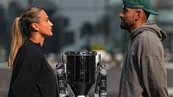 Tennis players Aryna Sabalenka of Belarus, left, and Nick Kyrgios of Australia face-off with the trophy during a press conference ahead of the Battle of the Sexes exhibition match at Atlantis The Royal in Dubai, United Arab Emirates, Saturday, Dec. 27, 2025. (AP Photo/ Fatima Shbair)