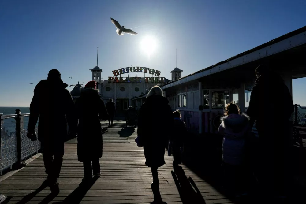 People walk on the Brighton Pier as a bird flies overhead during the Christmas holidays, in Brighton, East Sussex, Britain, December 27, 2025. REUTERS/Carlos Jasso     TPX IMAGES OF THE DAY / Foto: Carlos Jasso