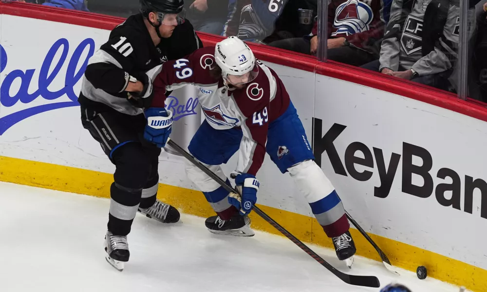 Los Angeles Kings right wing Corey Perry, left, fights for control of the puck with Colorado Avalanche defenseman Samuel Girard in the third period of an NHL hockey game Monday, Dec. 29, 2025, in Denver. (AP Photo/David Zalubowski)