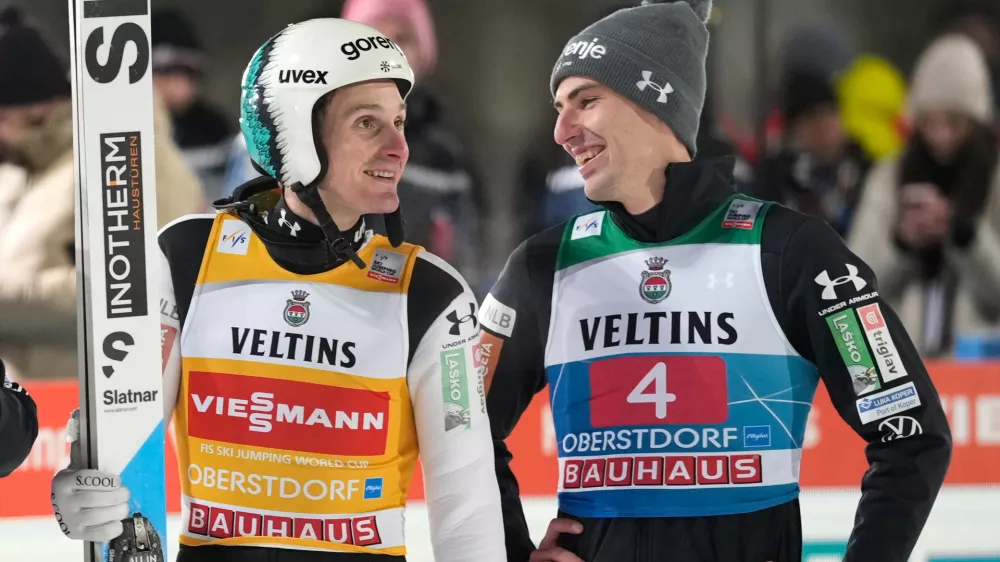 Domen Prevc, of Slovenia, after his second round jump, speaks with Timi Zajc, also of Slovenia, right, at the first stage of the Four Hills ski jumping tournament in Oberstdorf, Germany, Monday, Dec. 29, 2025. (AP Photo/Matthias Schrader)