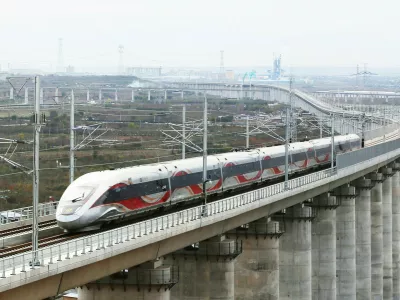 XI'AN, Nov. 17, 2025 -- A drone photo taken on Nov. 17, 2025 shows a test train running on a grand bridge of a high-speed railway line connecting Xi'an with Yan'an in northwest China's Shaanxi Province. A high-speed railway line connecting Xi'an, the capital of northwest China's Shaanxi Province, with Yan'an in northern Shaanxi has entered its trial operation phase, marking a significant step toward full operation. The trial run commenced on Monday morning when test train 55302 departed from Xi'an toward Yan'an -- transitioning from the joint debugging and testing phase to operational simulations. As the first high-speed railway in northern Shaanxi's old revolutionary base area, this 299.8-km project is designed for speeds of 350 km per hour and slashes the journey duration between Xi'an and Yan'an from 2.5 hours to approximately one hour. Yan'an holds profound historical significance -- as it served as the base of the Communist Party of China leadership between 1937 and 1947.,Image: 1052947556, License: Rights-managed, Restrictions:, Model Release: no