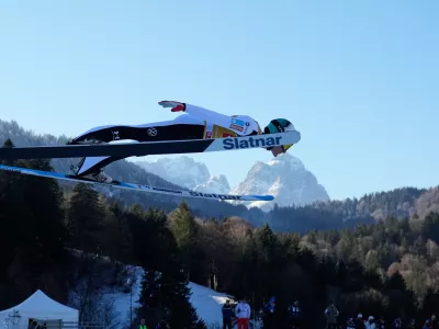 Domen Prevc, of Slovenia, soars through the air, with the Zugspitze and Waxenstein mountains in the background, during his trial jump at the second stage of the Four Hills ski jumping tournament in Garmisch-Partenkirchen, Germany, Wednesday, Dec. 31, 2025. (AP Photo/Matthias Schrader)