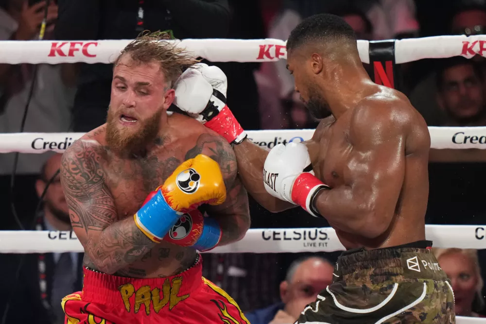 Anthony Joshua, right, punches Jake Paul during their heavyweight boxing match, Friday, Dec. 19, 2025, in Miami, Fla. (AP Photo/Lynne Sladky)