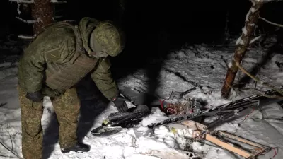 This image made from undated video provided by the Russian Defense Ministry Press Service on Wednesday, Dec. 31, 2025, shows a man in camouflage standing by a downed drone at an undisclosed location that it said was one of the Ukrainian drones involved in an alleged attack on a residence of President Vladimir Putin this week – a claim Kyiv has denied as a "lie". (Russian Defense Ministry Press Service via AP)