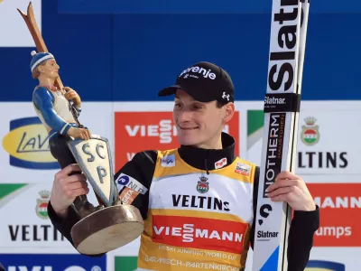 Ski Jumping - Four Hills Tournament - Garmisch-Partenkirchen, Germany - January 1, 2026 Slovenia's Domen Prevc celebrates on the podium with the trophy after winning the Men's Individual HS142 REUTERS/Kai Pfaffenbach
