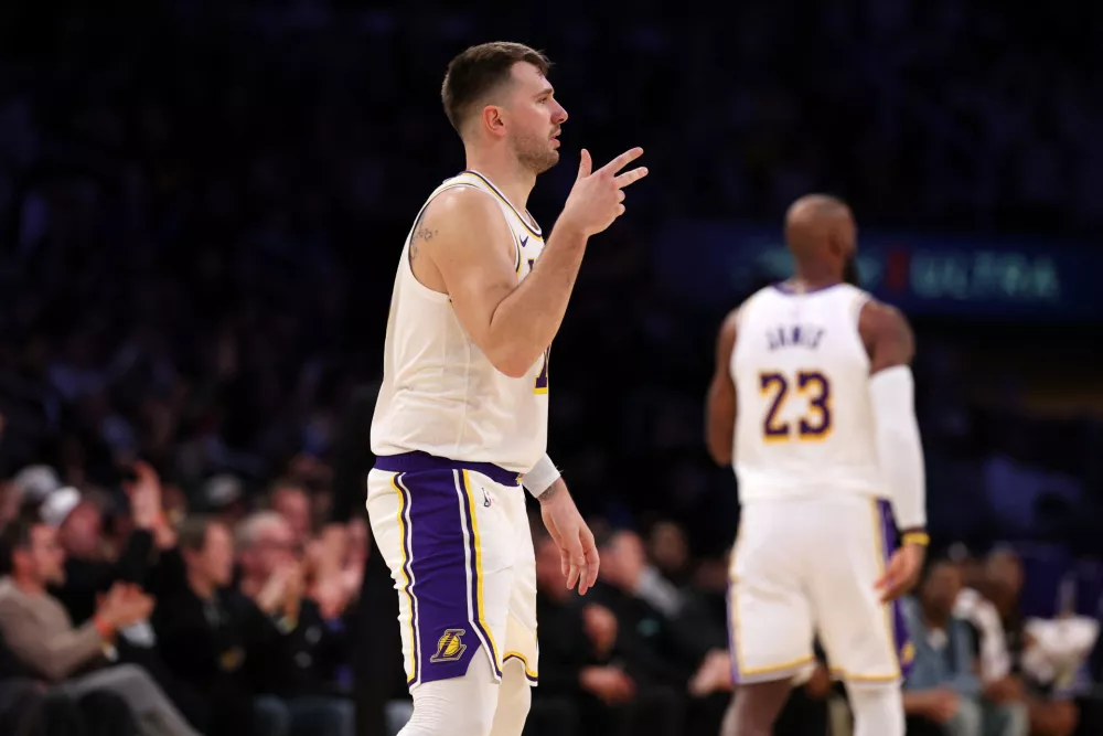 Jan 4, 2026; Los Angeles, California, USA; Los Angeles Lakers forward Luka Doncic (77) reacts after making a three point basket during the fourth quarter against the Memphis Grizzlies at Crypto.com Arena. Mandatory Credit: Kiyoshi Mio-Imagn Images