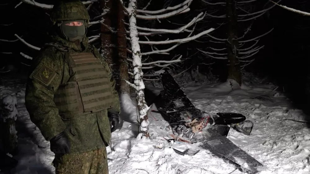 This image made from undated video provided by the Russian Defense Ministry Press Service on Wednesday, Dec. 31, 2025, shows a man in camouflage standing by a downed drone at an undisclosed location that it said was one of the Ukrainian drones involved in an alleged attack on a residence of President Vladimir Putin this week &ndash; a claim Kyiv has denied as a "lie". (Russian Defense Ministry Press Service via AP)