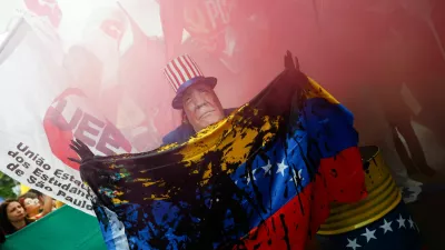 A man wears a mask depicting U.S. President Donald Trump during a protest against U.S. strikes on Venezuela and the capture of its President Nicolas Maduro, in Sao Paulo, Brazil January 5, 2026. REUTERS/Tuane Fernandes