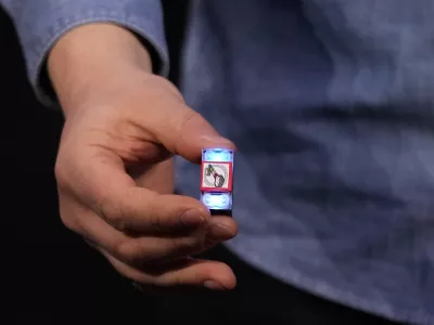 A LEGO smart brick is held during a LEGO news conference ahead of the CES tech show Monday, Jan. 5, 2026, in Las Vegas. (AP Photo/Abbie Parr)