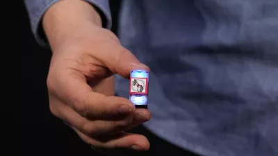 A LEGO smart brick is held during a LEGO news conference ahead of the CES tech show Monday, Jan. 5, 2026, in Las Vegas. (AP Photo/Abbie Parr)