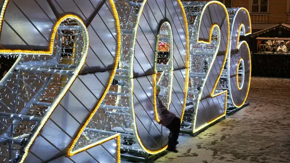 A girl sits in digit 2026 at a Christmas fair opened prior to Christmas and New Year festivities in St. Petersburg, Russia, Tuesday, Dec. 30, 2025. (AP Photo/Dmitri Lovetsky) / Foto: Dmitri Lovetsky