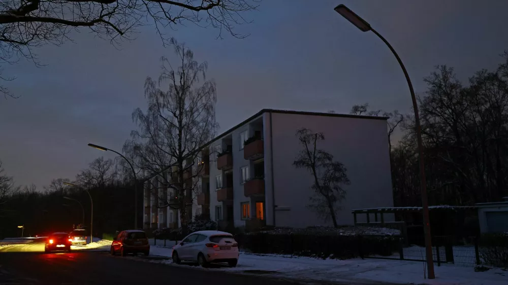 A car drives past an apartment block during a blackout, which left thousands of homes without power after a suspected arson attack at the Lichterfelde power plant in the Steglitz-Zehlendorf district in southern Berlin, Germany, January 6, 2026. REUTERS/Lisi Niesner